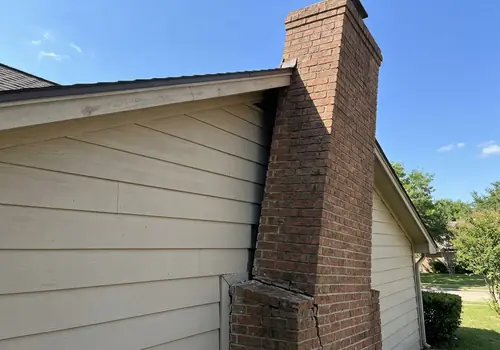 Exterior brick chimney pulling away from residential siding due to foundation footing failure